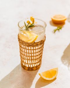 A rattan glass filled with Sparkling Rosemary Ginger Lemonade