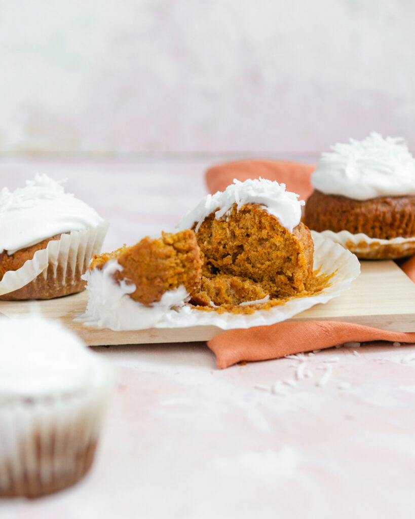 a cutting board with carrot cake muffins