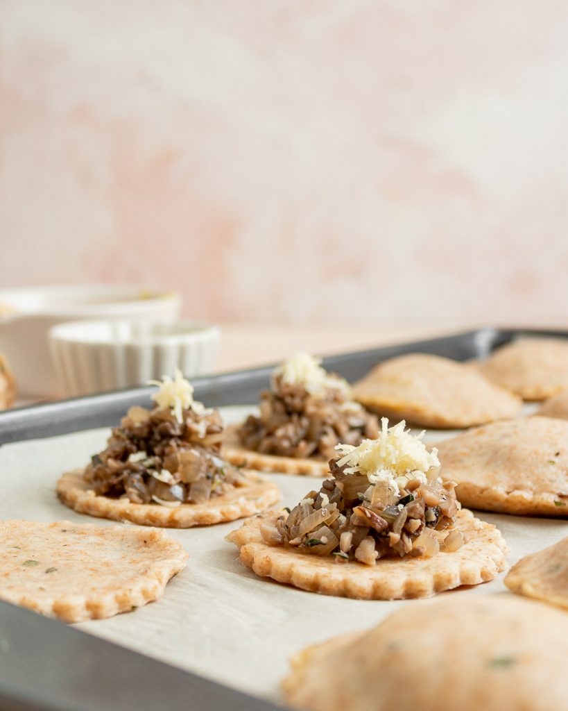 Savory hand pies assembled with sprinkled cheese
