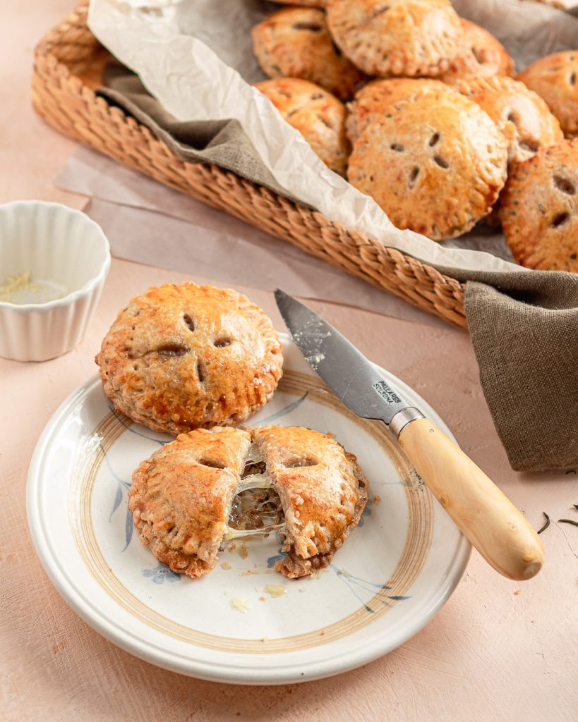 freshly baked savory hand pie cut in half with gooey cheese