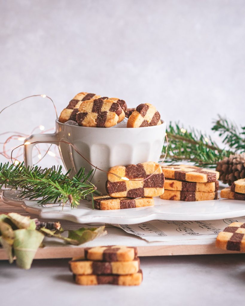 Checkerboard cookies stacked in a white mug