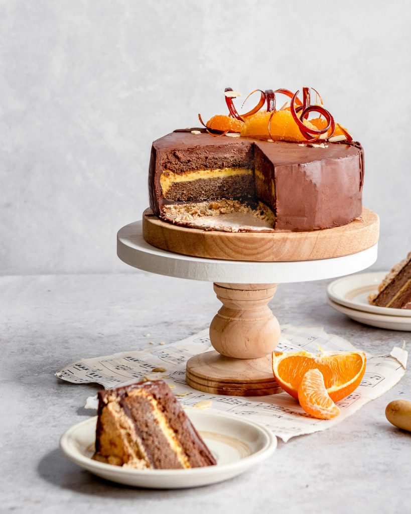slicing into a citrus chocolate layer cake