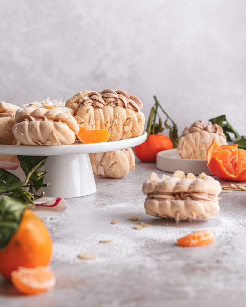 A platter serving clementine mocha meringue sandwich cookies with cream