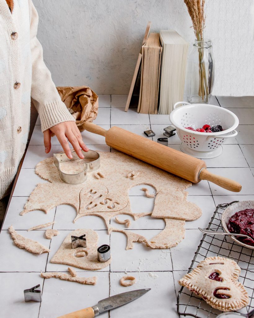 making hand pies by rolling out the dough in a kitchen