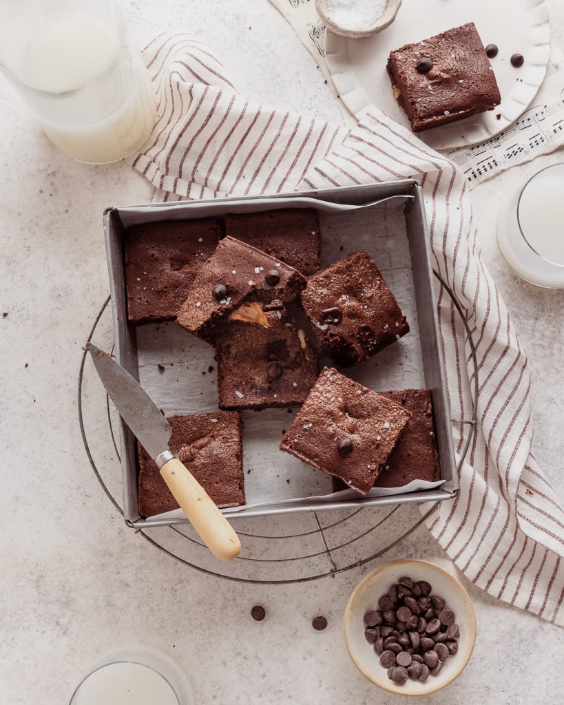 caramel brownies being cut in a pan