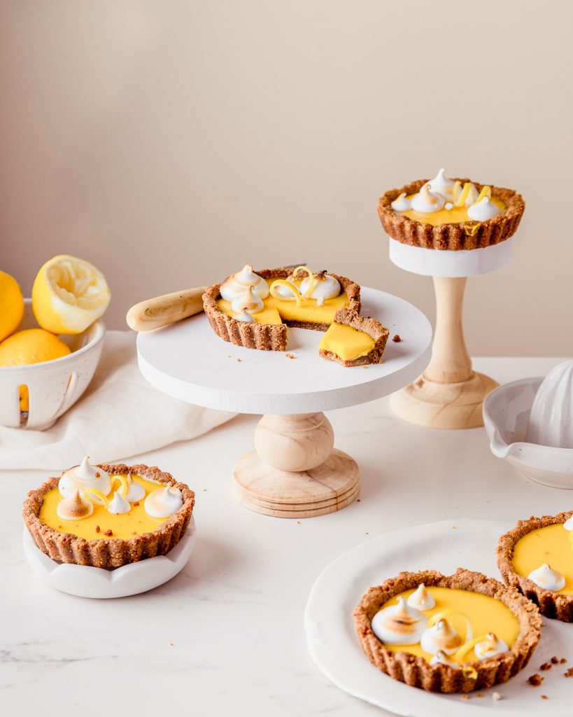 lemon tarts with a bite taken out of a slice