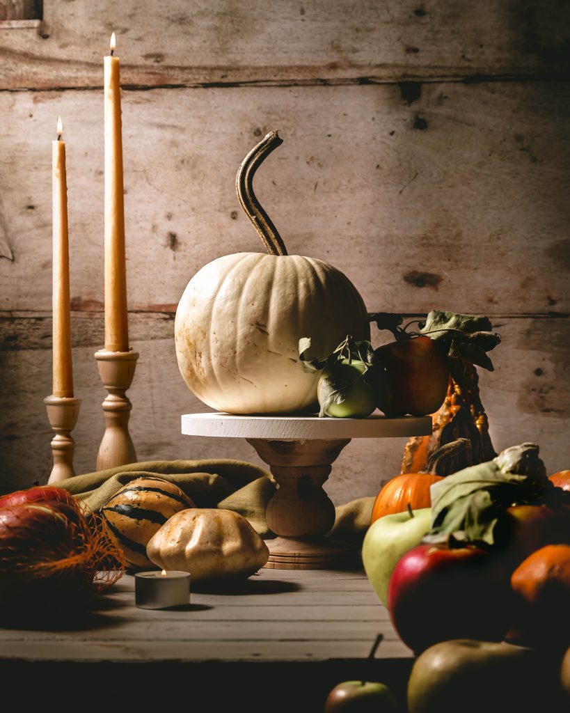 Fall pumpkin table spread with dandles and apples on a farmhouse wooden table